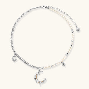 Silver-toned crescent moon pendant with star accents on pearl and chain necklace against white background.